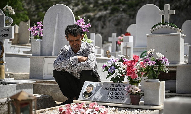Esfandiyar Fagkiri, 38, sits next to the grave of his son Hasibollah, who was accidentally killed last year at the age of five by a truck in a Greek migrant camp, at the Orthodox cemetery of Schisto, on the western outskirts of Athens, on May 10. &mdash; AFP