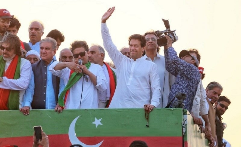 Imran Khan waves to supporters on a truck. —PTI/Twitter