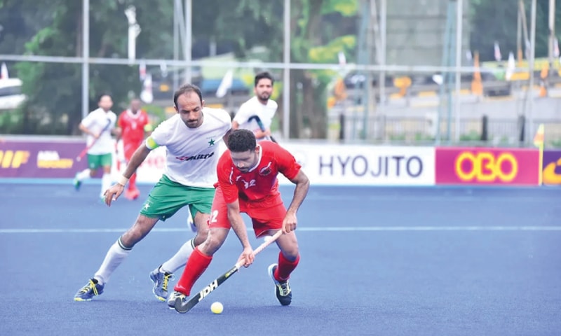 JAKARTA: Pakistan captain Umar Bhutta (L) challenges an Oman player during their fifth-place classification match at the Asia Cup on Saturday.—courtesy AHF