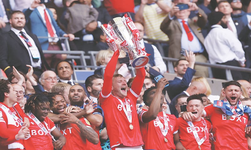 LONDON: Nottingham Forest’s Joe Worrall lifts the trophy as he celebrates with team-mates after winning the Championship play-off final against Huddersfield Town at Wembley.—Reuters LONDON: Nottingham Forest’s Joe Worrall lifts the trophy as he celebrates with team-mates after winning the Championship play-off final against Huddersfield Town at Wembley.—Reuters