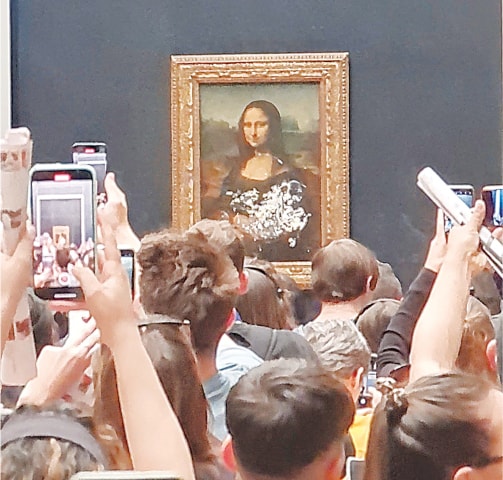VISITORS take pictures and video of the &lsquo;Mona Lisa&rsquo; after cake was smeared on the protective glass around it, at the Louvre Museum in Paris.&mdash;Reuters