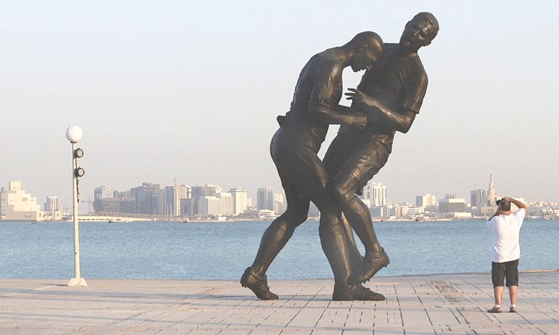 DOHA: An Oct 7, 2013, file photo shows a man taking pictures of a bronze sculpture, Coup de Tete by Algerian-born French artist Adel Abdessemed, during its installation in Doha, Qatar. The work portrays French footballer Zinedine Zidane headbutting Italian player Marco Materazzi during the 2006 World Cup.&mdash;Reuters