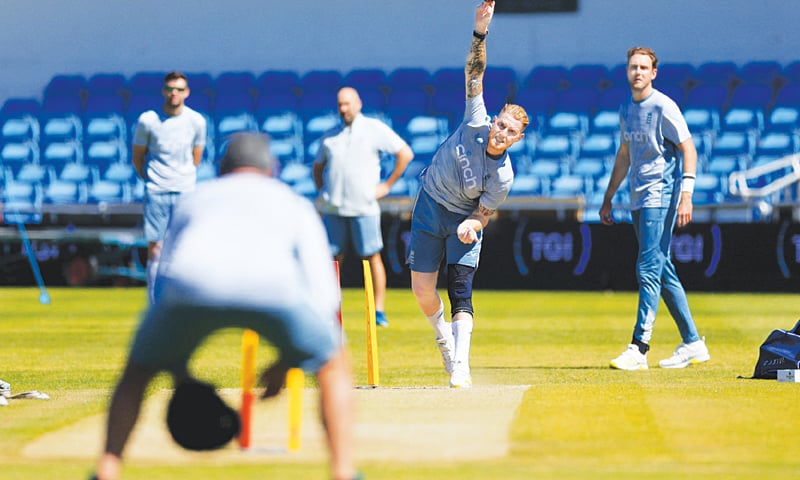 LEEDS: England captain Ben Stokes bowls as team-mate Stuart Broad (R) looks on during a practice session at Headingly on Wednesday.—Reuters