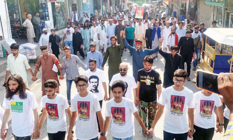 Participants of the JKLF ‘long march’ parade through a street in Kotli on Sunday. — Dawn Participants of the JKLF ‘long march’ parade through a street in Kotli on Sunday. — Dawn