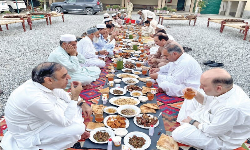 People enjoy traditional meal on Eidul Azha in a village hujra. &mdash; Dawn file photo
