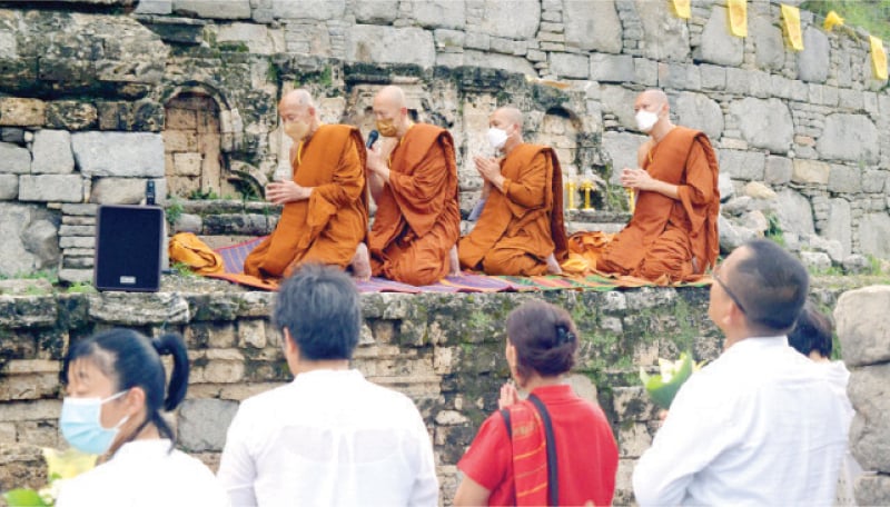 Thai monks and disciples perform rituals in connection with monastic practices of ‘rain retreat’ at Dharmarajia Stupa near Taxila on Thursday. — Dawn