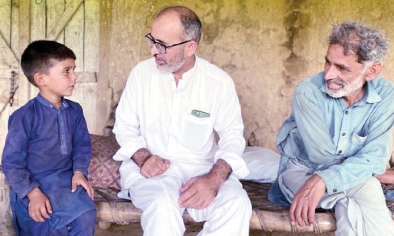 Provincial education secretary Mutasim Billah Shah talks to a child during his visit to a Swabi village.— Dawn Provincial education secretary Mutasim Billah Shah talks to a child during his visit to a Swabi village.— Dawn