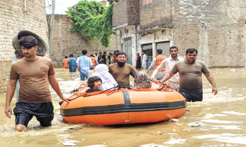 Rescue workers evacuate families stranded in Shabqadar area of Charsadda district on Saturday. — Dawn