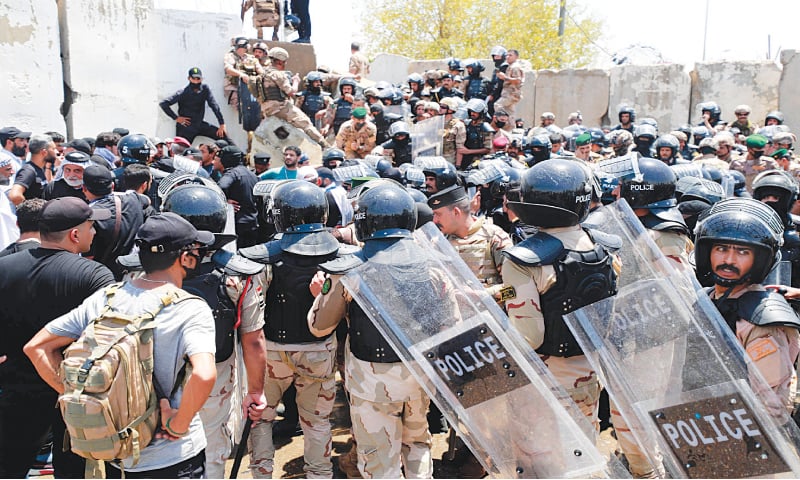 SECURITY forces gather as supporters of Moqtada Sadr bring down concrete barriers leading to Baghdad’s high-security Green Zone and the country’s parliament, during a protest against a rival bloc’s nomination for prime minister.—AFP SECURITY forces gather as supporters of Moqtada Sadr bring down concrete barriers leading to Baghdad’s high-security Green Zone and the country’s parliament, during a protest against a rival bloc’s nomination for prime minister.—AFP