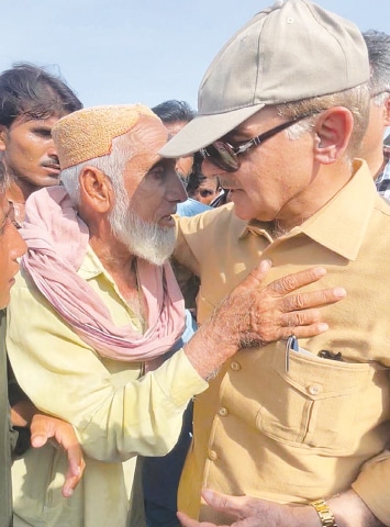 Prime Minister Shehbaz Sharif interacts with flood-hit residents of Shambani village in Jhal Magsi. He arrived in Balochistan on Saturday to review rescue and relief operations.—APP