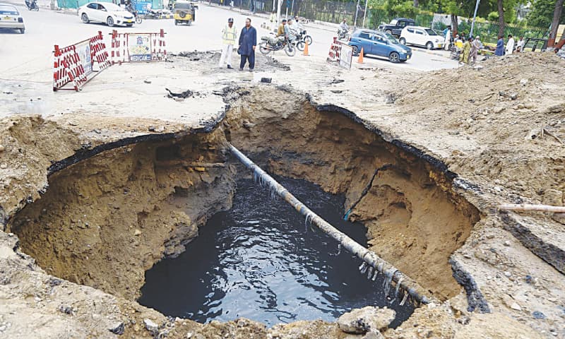 Traffic police place barricades around a sinkhole that developed in the PIB Colony area on Sunday.—PPI