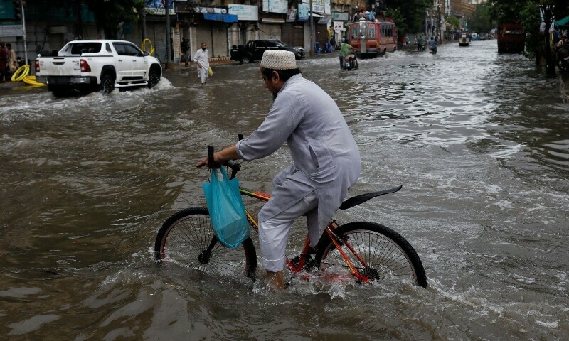 A man rides bicycle along a flooded road, following heavy rains during the monsoon season in Karachi, Pakistan July 25, 2022. — Reuters