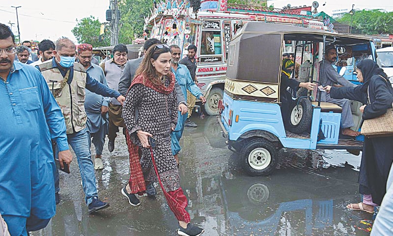 Federal Minister Sherry Rehman visits a rain-hit area in the city on Monday.—APP