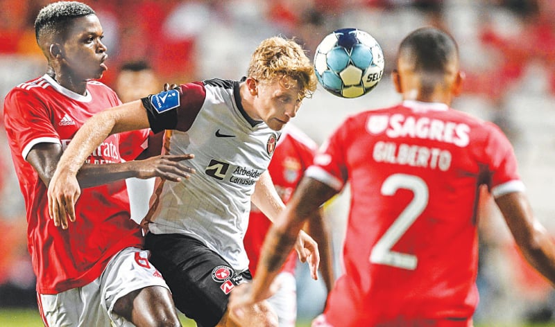 LISBON: Midtjylland’s Oliver Sorensen (C) vies for a header with Benfica’s Florentino Luis during the first leg of their UEFA Champions League third qualifying round tie at the Luz Stadium.—AFP LISBON: Midtjylland’s Oliver Sorensen (C) vies for a header with Benfica’s Florentino Luis during the first leg of their UEFA Champions League third qualifying round tie at the Luz Stadium.—AFP