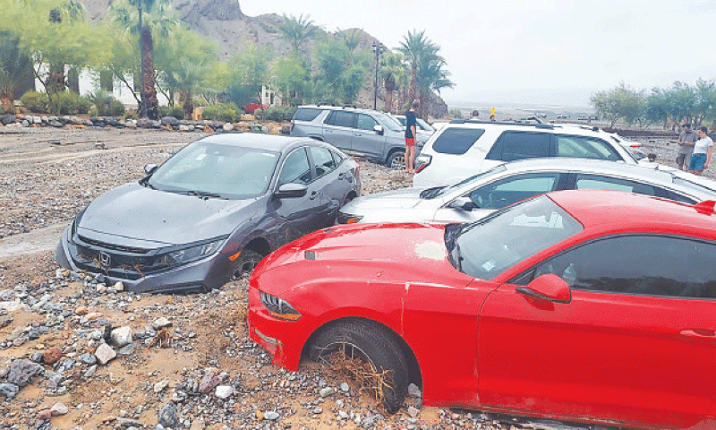 <p>Stranded visitors and park staff standing by some of the sixty cars immobilised by debris from the rain in Death Valley.—AFP</p>