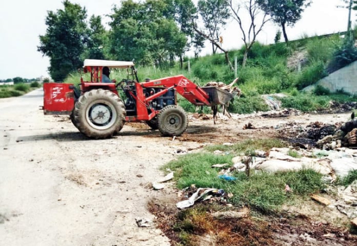 TMA officials dispose of carcasses of cattle in Hazro. — Dawn