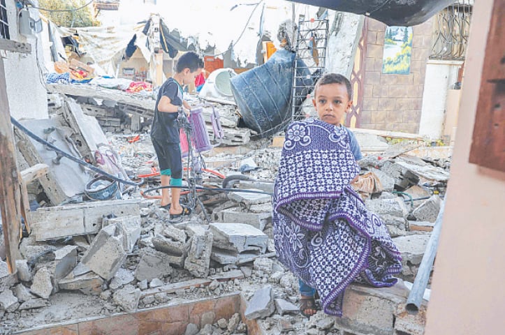 PALESTINIAN youths salvage belongings from the rubble of their house, which was destroyed during Israel’s air strikes in Rafah last week.—AFP