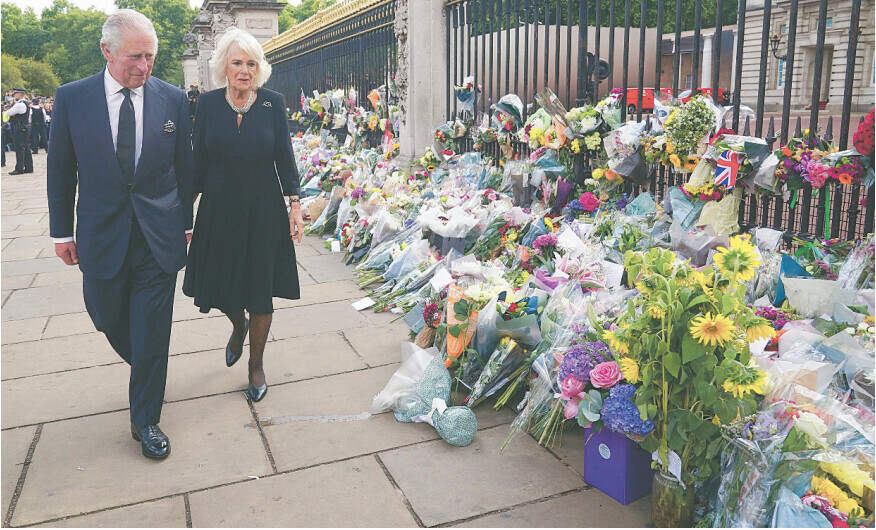 King Charles and Camilla view floral tributes left outside Buckingham Palace after Queen Elizabeth’s death.—AFP