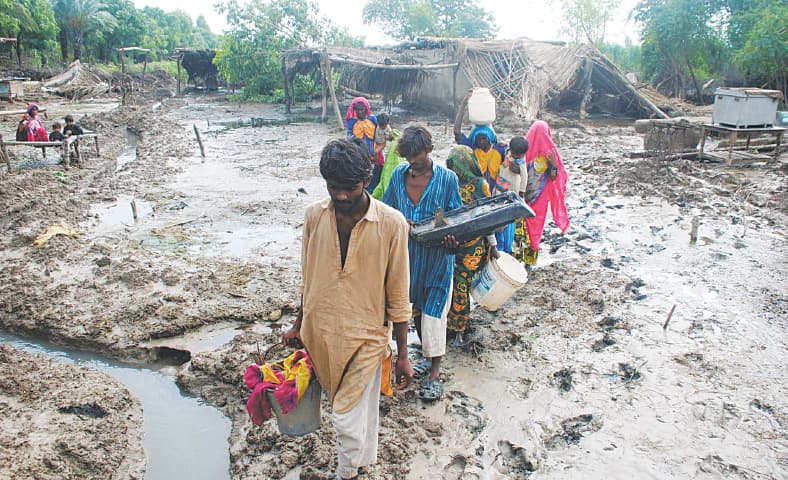 Residents in a village of Matiari district in Sindh retrieve some of their belongings from their destroyed homes | Umair Ali