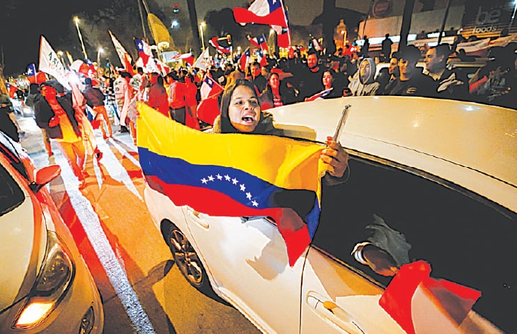 A WOMAN holds a Venezuelan flag as supporters of “I reject” option react to early results of the referendum on a new Chilean constitution in Valparaiso on Monday.—Reuters A WOMAN holds a Venezuelan flag as supporters of “I reject” option react to early results of the referendum on a new Chilean constitution in Valparaiso on Monday.—Reuters