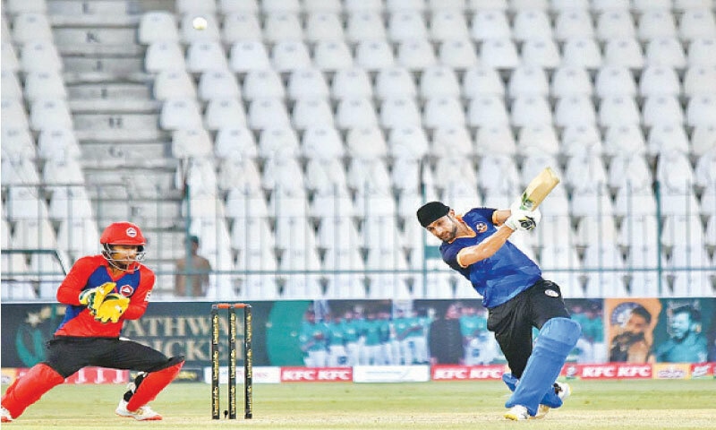 MULTAN: Central Punjab all-rounder Shoaib Malik plays a shot as Northern wicket-keeper Rohail Nazir looks on during their National T20 Cup match at the Multan Cricket Stadium on Friday.&mdash;APP