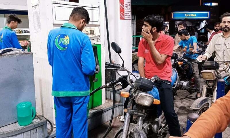 KARACHI, PAKISTAN, JUN 02: Fuel station worker filling petrol in vehicle, at Fuel Station in 
Karachi on Thursday, June 02, 2022. The government has jacked up petrol prices by Rs30 to a 
A commuter looks at a fuel pump as a worker fills fuel in his motorcycle in Karachi. — APP/File