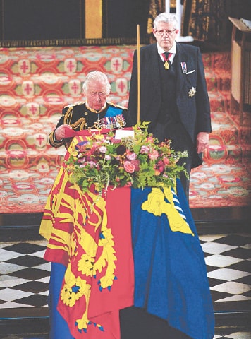 King Charles III places the colours of the Grenadier Guards on the coffin of his mother, Queen Elizabeth II, at her Committal Service in St George’s Chapel inside Windsor Castle on Monday.—AFP