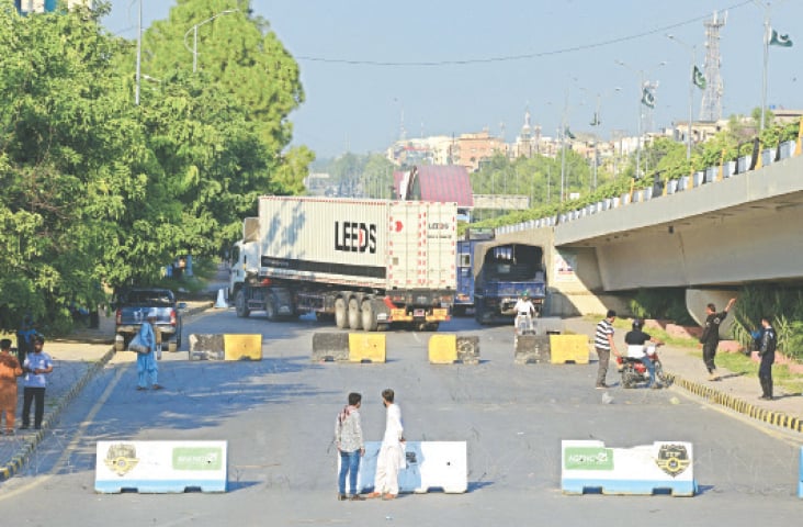 ISLAMABAD: Police block Jinnah Avenue during a sit-in by farmers on Thursday.—Mohammad Asim / White Star