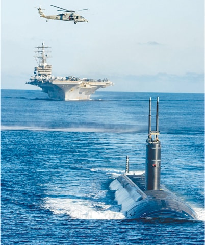 A HANDOUT photo released by South Korea’s defence ministry shows the US Navy’s nuclear-powered USS Annapolis submarine (bottom) and the nuclear-powered USS Ronald Reagan aircraft carrier (centre) during a trilateral anti-submarine exercise held by South Korea, the United States and Japan in international waters off the Korean peninsula.—AFP