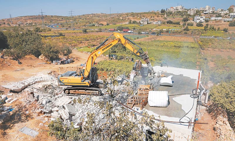 ISRAELI bulldozers demolish a Palestinian house in Hebron, occupied West Bank, on Monday.—AFP ISRAELI bulldozers demolish a Palestinian house in Hebron, occupied West Bank, on Monday.—AFP