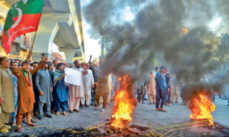 PTI supporters chant slogans and burn tyres in Peshawar on Friday to protest the Election Commission’s decision to disqualify their party chief Imran Khan. — White Star PTI supporters chant slogans and burn tyres in Peshawar on Friday to protest the Election Commission’s decision to disqualify their party chief Imran Khan. — White Star