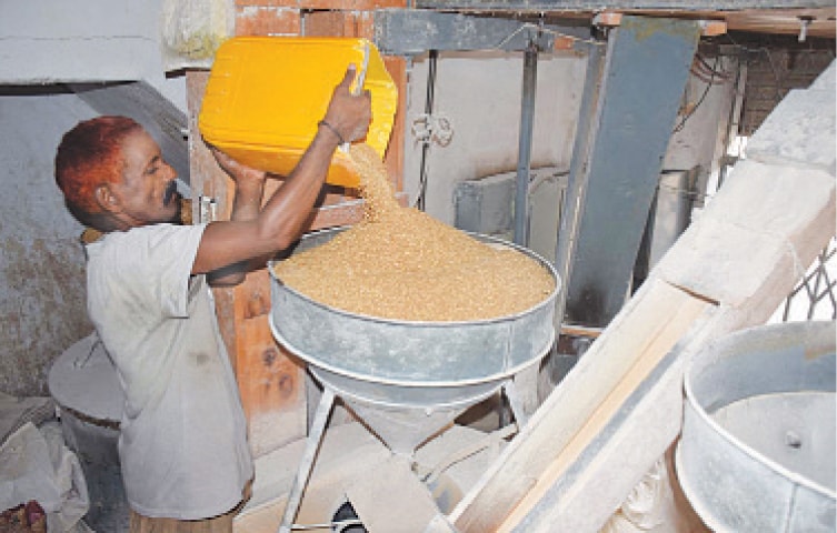 A worker is making flour at a chakki in Hyderabad. &mdash;Photo by Umair Ali