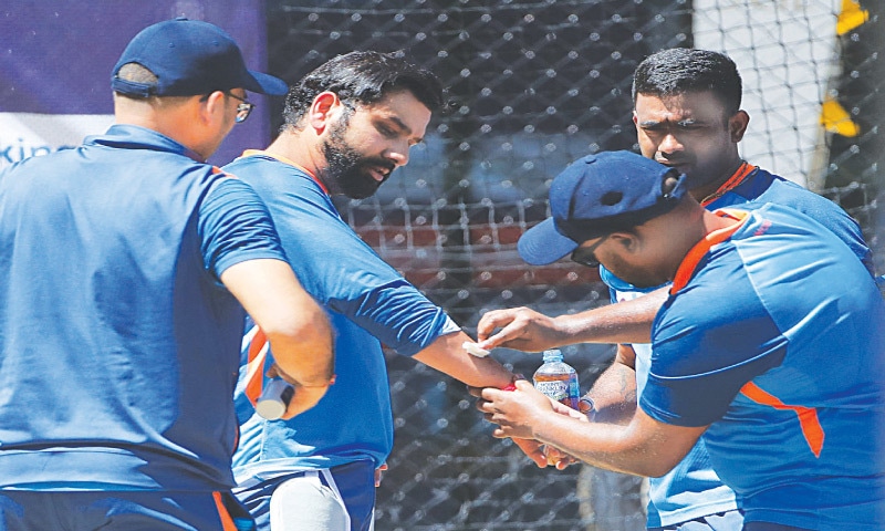 ADELAIDE: Indian captain Rohit Sharma (C) receives medical attention after being hit by a ball during a net practice session at Adelaide Oval on Tuesday. Sharma was hit on the forearm during a throwdown session and gave up batting. The right-hander, however, returned to bat after 45 minutes, defending a few easy throwdowns before going on to bat normally. The injury scare seemed to have concerned the team’s staff members before the confirmation that the risk around Sharma’s availability for Thursday’s semi-final against England was low.—AFP ADELAIDE: Indian captain Rohit Sharma (C) receives medical attention after being hit by a ball during a net practice session at Adelaide Oval on Tuesday. Sharma was hit on the forearm during a throwdown session and gave up batting. The right-hander, however, returned to bat after 45 minutes, defending a few easy throwdowns before going on to bat normally. The injury scare seemed to have concerned the team’s staff members before the confirmation that the risk around Sharma’s availability for Thursday’s semi-final against England was low.—AFP