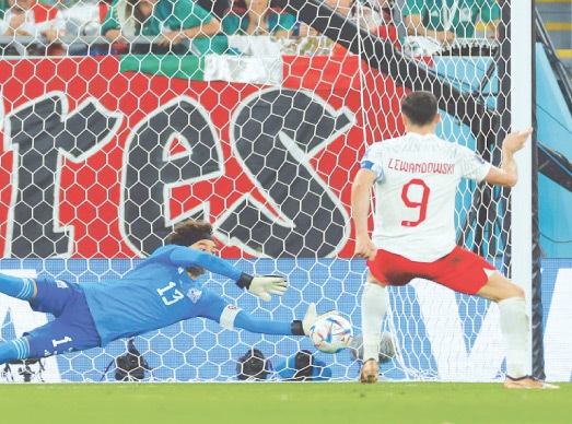 DOHA: Mexico goalkeeper Guillermo Ochoa saves a penalty by Robert Lewandowski of Poland during their Group &lsquo;C&rsquo; match at Stadium 974 on Tuesday.&mdash;AFP