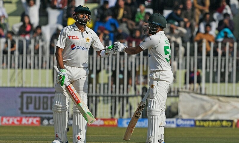 Pakistan’s captain Babar Azam (L) celebrates with teammate Saud Shakeel after scoring half century (50 runs) during the third day of the first cricket Test match between Pakistan and England at the Rawalpindi Cricket Stadium, in Rawalpindi on December 3, 2022. — AFP