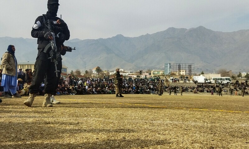 A Taliban security personnel stands guard as people attend to watch publicly flogging of women and men at a football stadium in Charikar city of Parwan province on December 8, 2022. - The Taliban flogged 27 Afghans, including women, in front of a large crowd December 8, a day after publicly executing a convicted murderer for the first time since they returned to power last year. — AFP