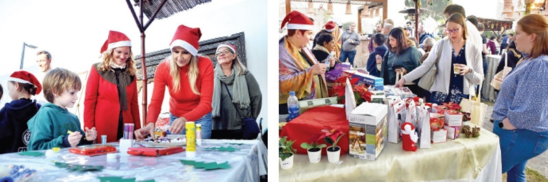 Women help children draw while visitors look at various items at the Christmas Market in Islamabad on Sunday. — APP & White Star