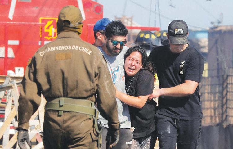 A woman cries after a forest fire destroyed her home in the hills of Chile’s Valparaiso region on Friday.—AFP