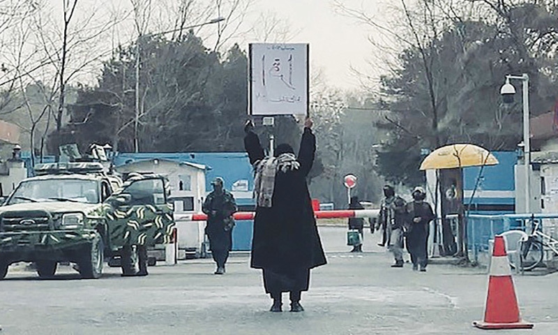 An 18-year-old Afghan student protests alone against the ban on women’s higher education, outside the Kabul University as members of Taliban forces stand guard.—AFP