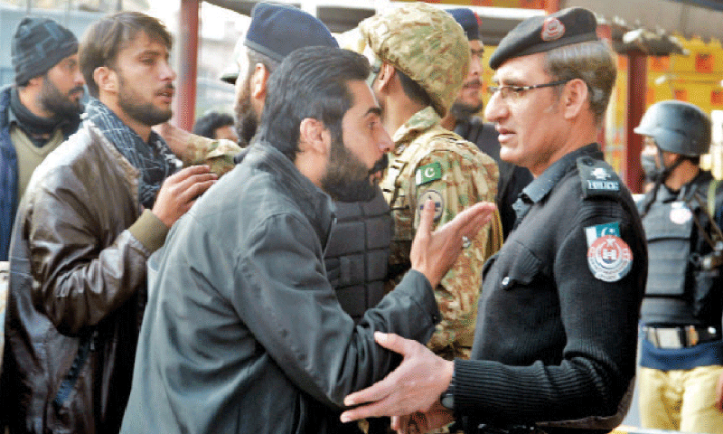 A relative of a blast victim argues with a policeman outside the police headquarters. — White Star