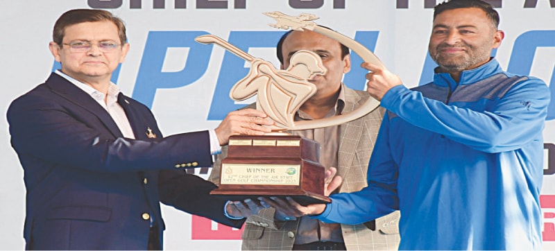 KARACHI: Shabbir Iqbal (R) poses with the CAS Open trophy after winning the championship here at the Airmen Golf Club on Sunday.