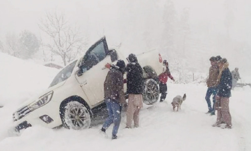 Police personnel trying to rescue passengers from a vehicle, which skidded off the road near Baradam area of Lower Chitral. &mdash; Dawn