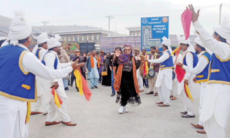 A foreigner dances with folk performers at Gandhara festival in Taxila on Sunday. — DAWN A foreigner dances with folk performers at Gandhara festival in Taxila on Sunday. — DAWN