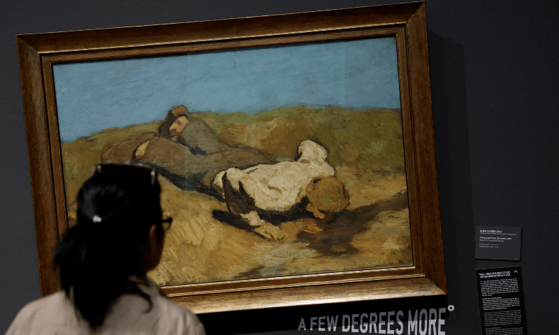 A visitor looks at A Boy at the Spring by Albin Egger Lienz at Leopold museum after it tilted 15 of its paintings to draw attention to climate change.—Reuters