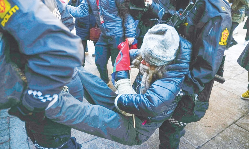 Policewomen carry away Greta Thunberg as she demonstrated with other campaigners outside the ministry of finance on Wednesday.—AFP