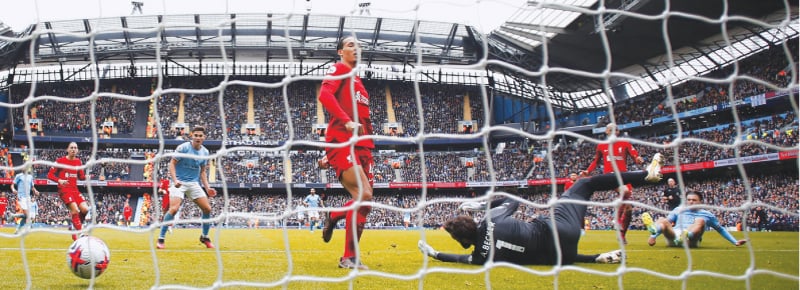 MANCHESTER: Manchester City&rsquo;s Jack Grealish (R) scores past Liverpool goalkeeper Alisson during their Premier League match at the Etihad Stadium on Saturday.&mdash;Reuters