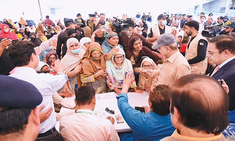 FAISALABAD: PM Shehbaz Sharif speaks to women queuing for free wheat flour at a distribution point, on Tuesday.—APP FAISALABAD: PM Shehbaz Sharif speaks to women queuing for free wheat flour at a distribution point, on Tuesday.—APP