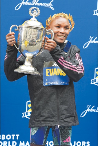 EVANS Chebet of Kenya holds the trophy after winning the the Boston Marathon.&mdash;Reuters