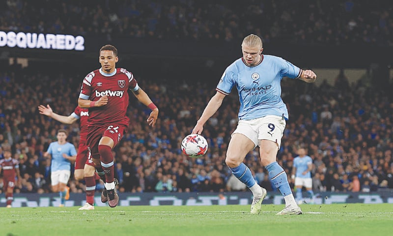 MANCHESTER: Erling Braut Haaland (R) of Manchester City chips to score during the Premier League match against West Ham United at the Etihad Stadium.&mdash;Reuters