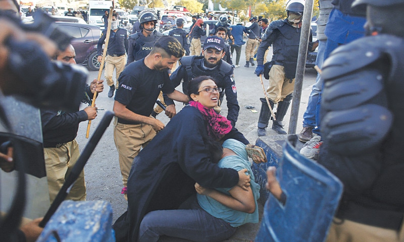  A woman PTI supporter shields her younger brother from a baton charge during the party’s protest near Millennium Mall — Shakil Adil / White Star 